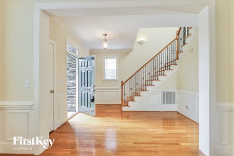 A spacious hallway with a staircase leading to the second floor.