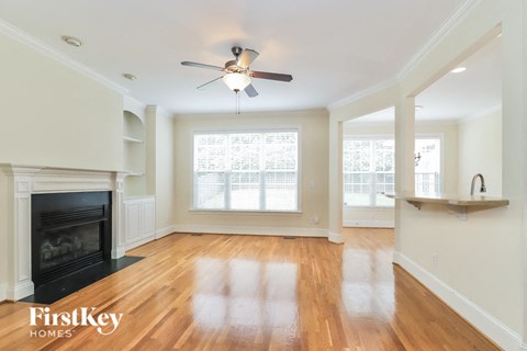 A spacious living room with wood floors and a fireplace.