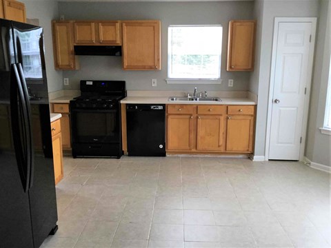 a kitchen with black appliances and wooden cabinets