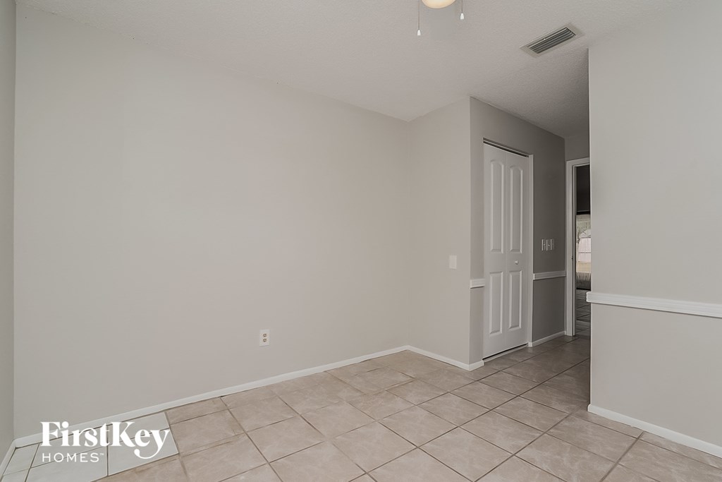 the living room and dining room of a house with a tiled floor