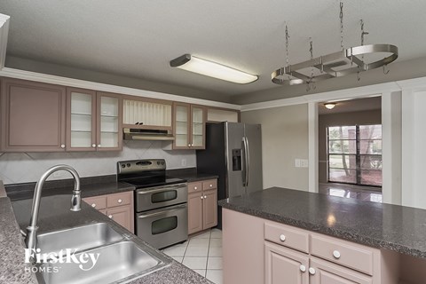 a kitchen with granite counter tops and stainless steel appliances