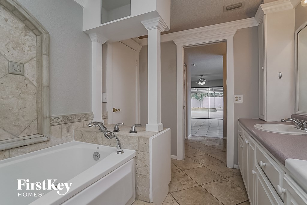 a bathroom with a tub and a sink and a mirror