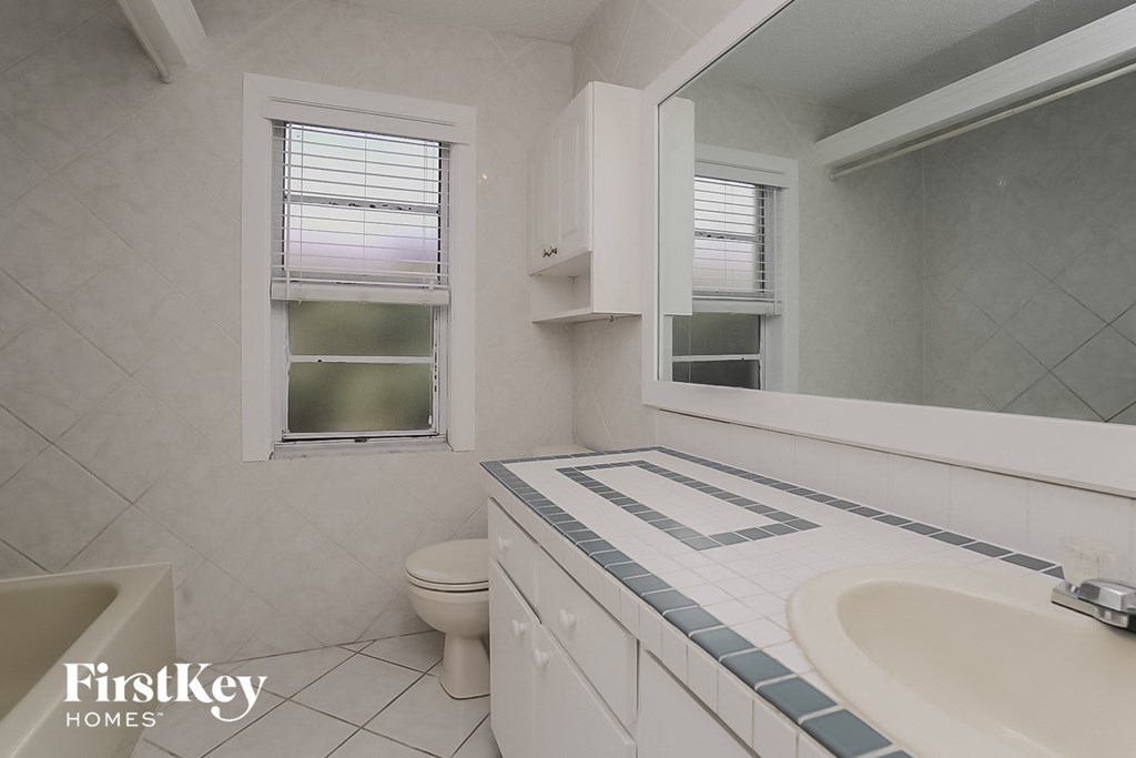 a bathroom with a sink toilet and a mirror