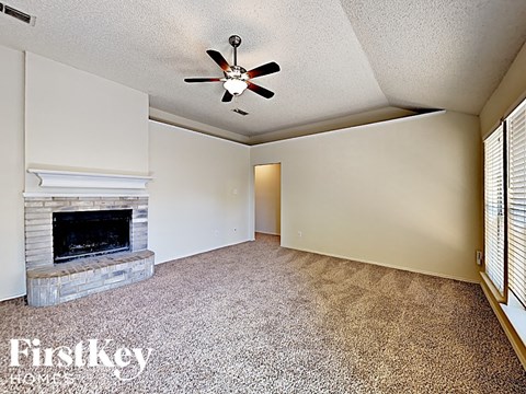A room with a fireplace and a ceiling fan.