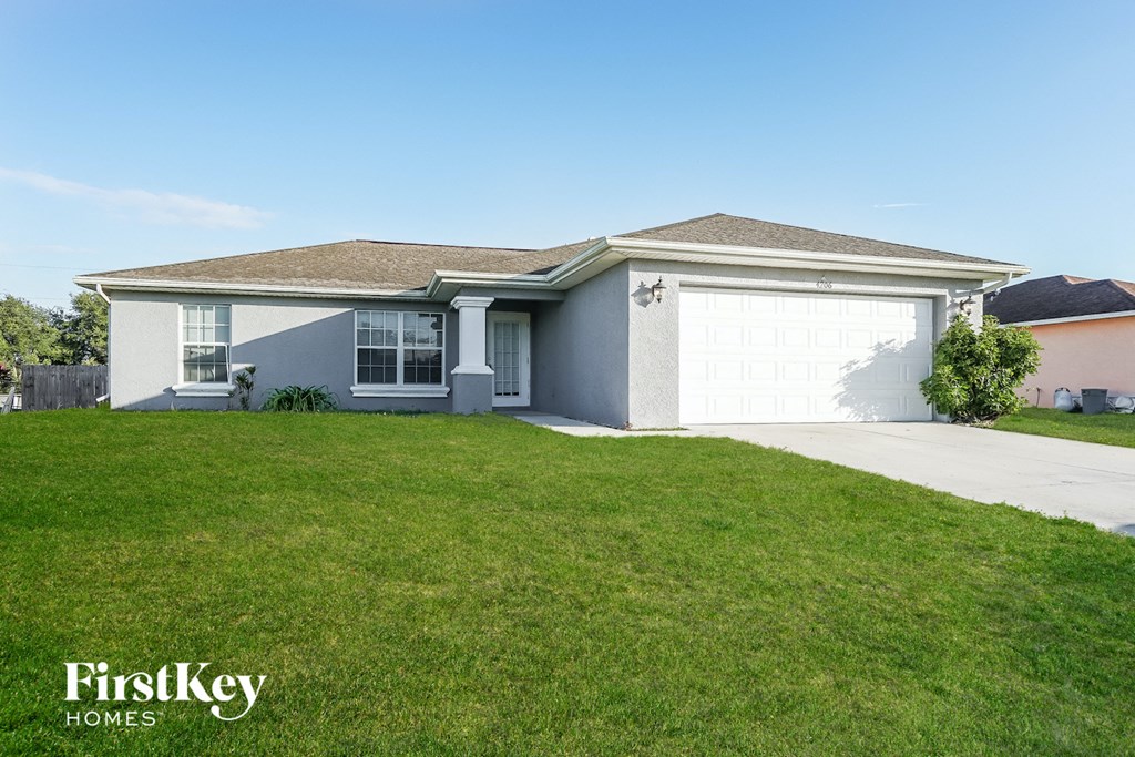 A house with a garage and a lawn in front.