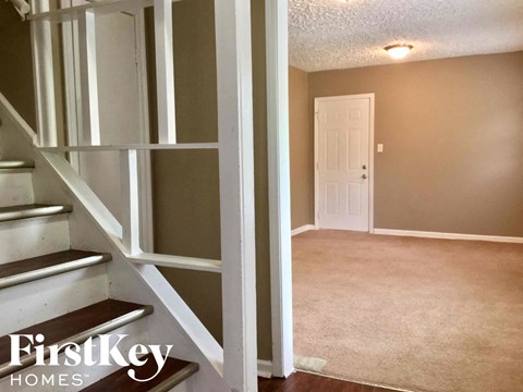 a walk in closet with white shelves and a white door