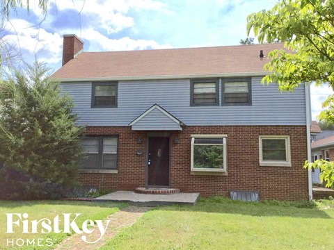 a brick house with a blue roof and a front porch