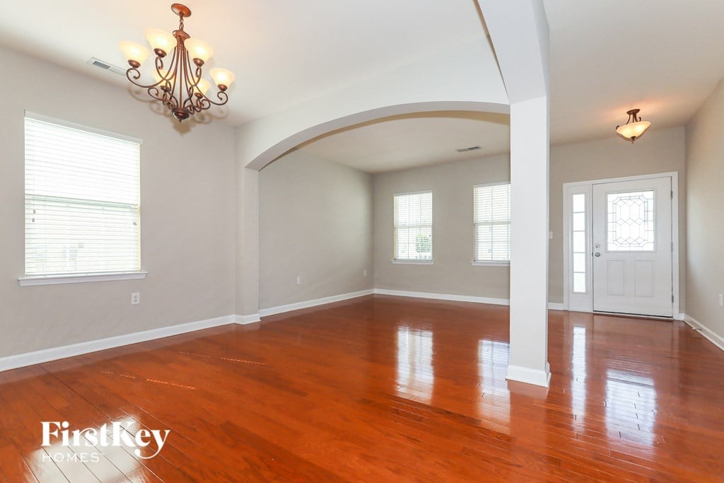 an empty living room with wood floors and a white door