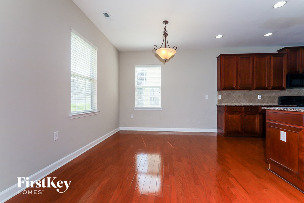 a kitchen and dining room with wood floors and white walls