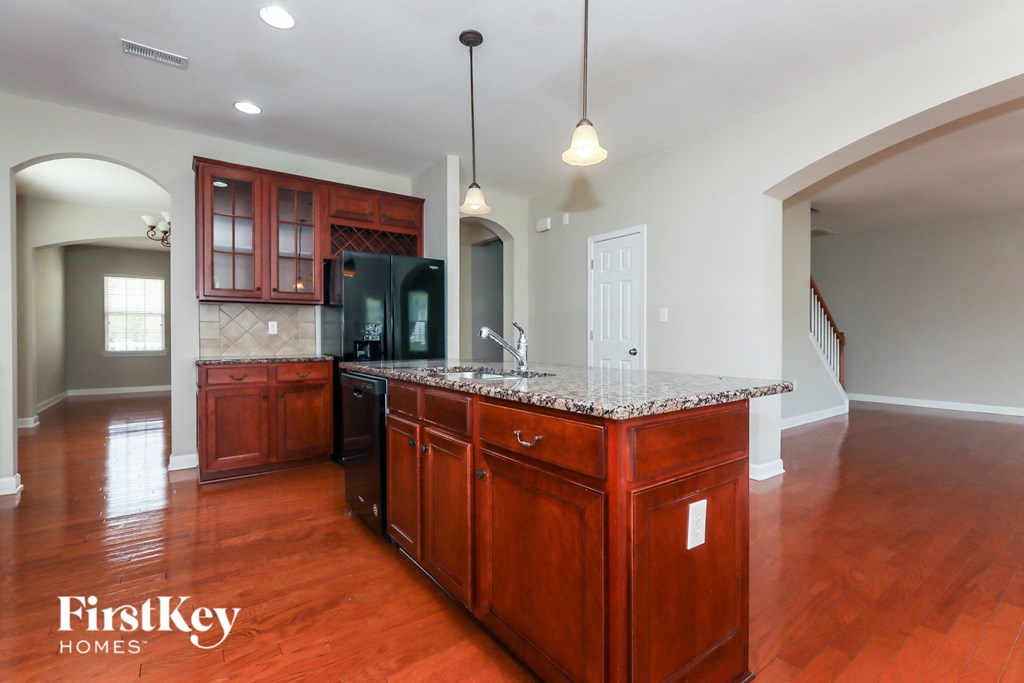 a kitchen with a granite counter top and wooden cabinets