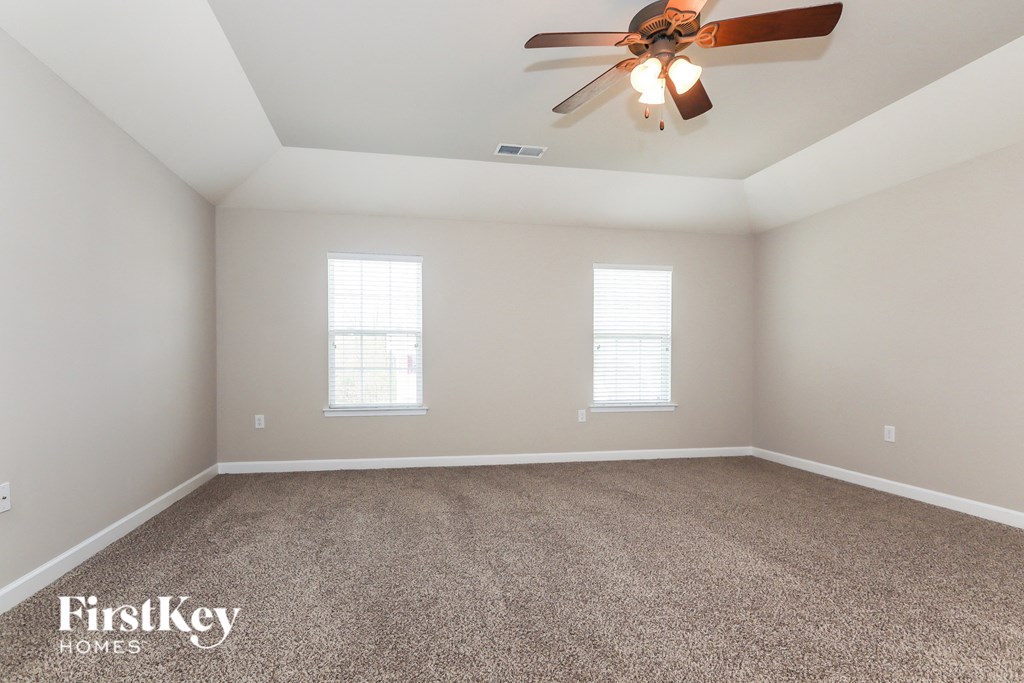 a bedroom with carpet and a ceiling fan