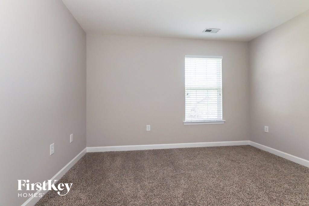 a empty room with carpet and a window