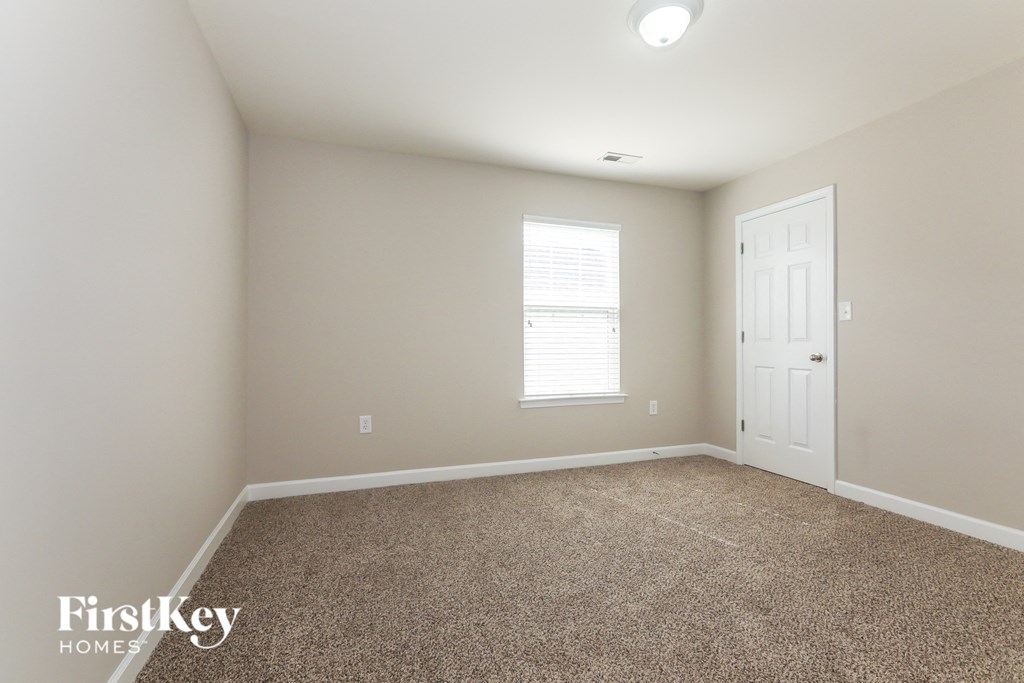 a empty room with carpet and a white door