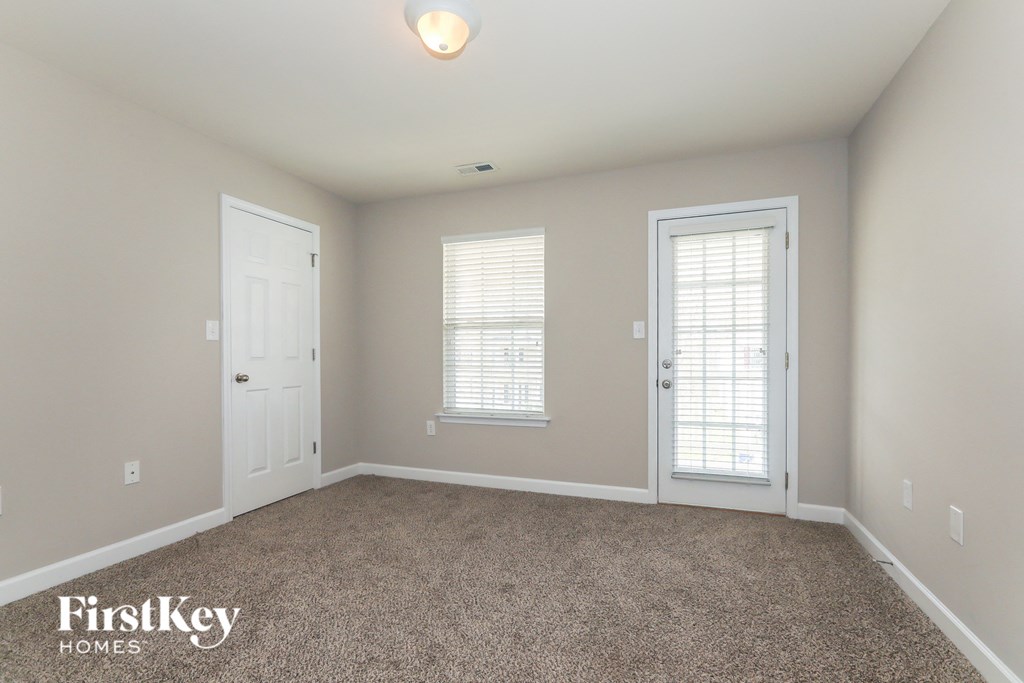 a bedroom with a carpeted floor and two doors