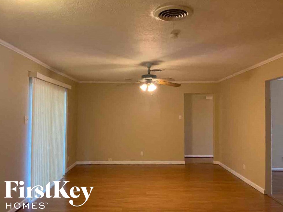 A room with a ceiling fan and wooden floors.