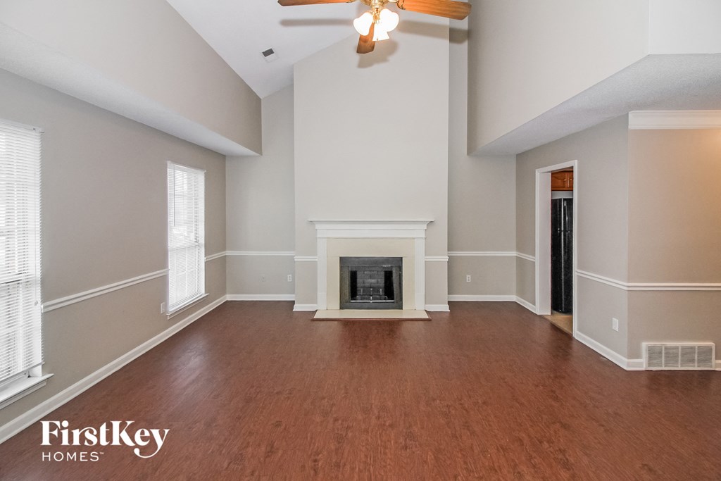 A spacious living room with a fireplace and wood flooring.