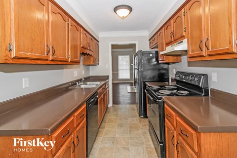 A kitchen with wooden cabinets and a black refrigerator.