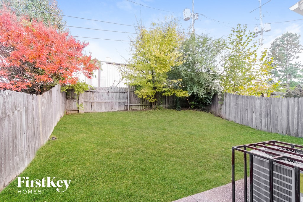 A backyard with a fence and trees.