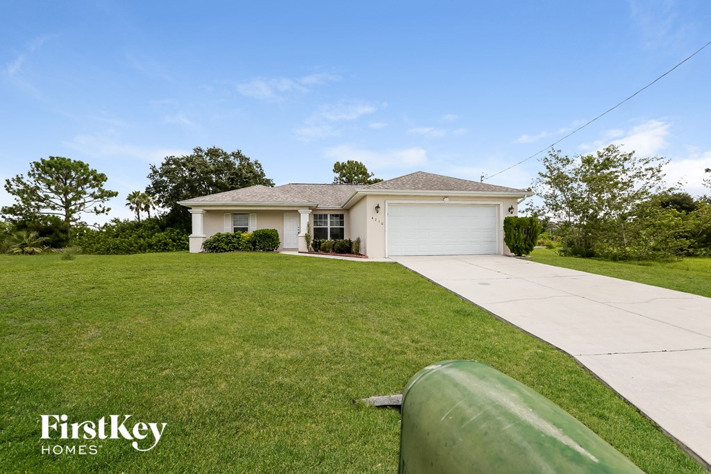 A house with a green lawn and a garage door.