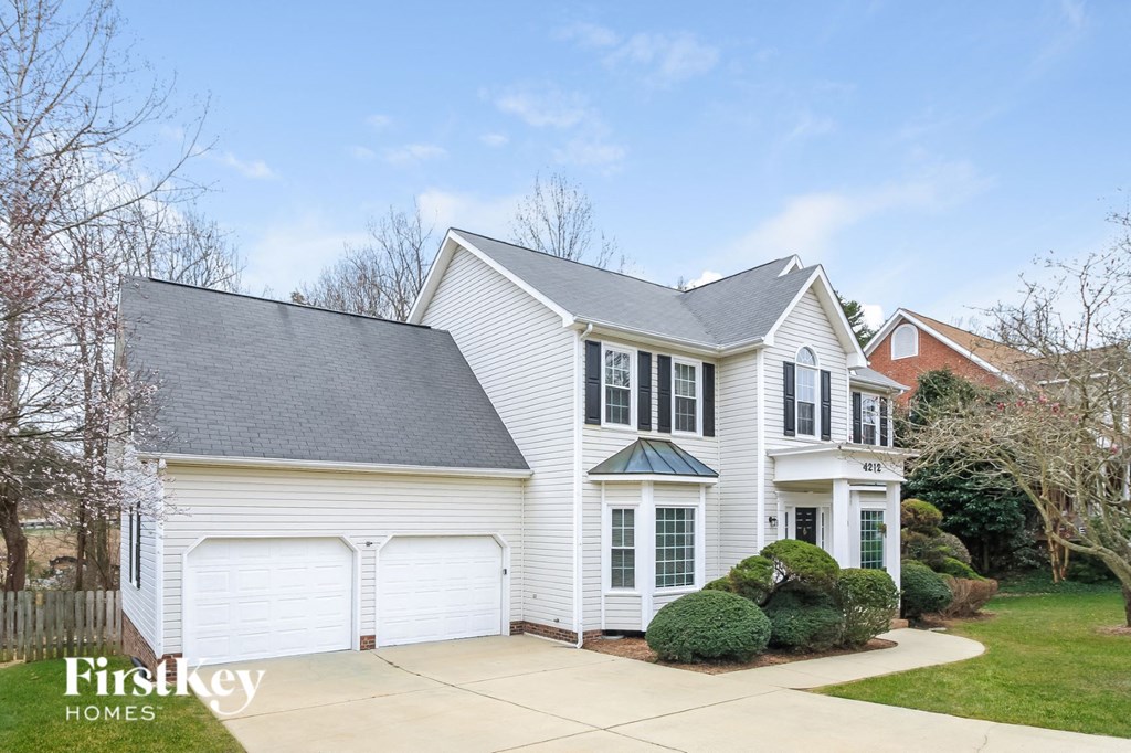 A white house with a black roof and a sign that says "Firstkey Homes".