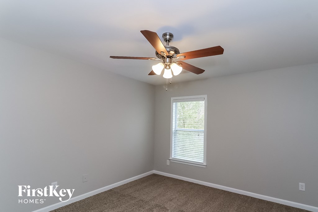 a bedroom with a ceiling fan and a window