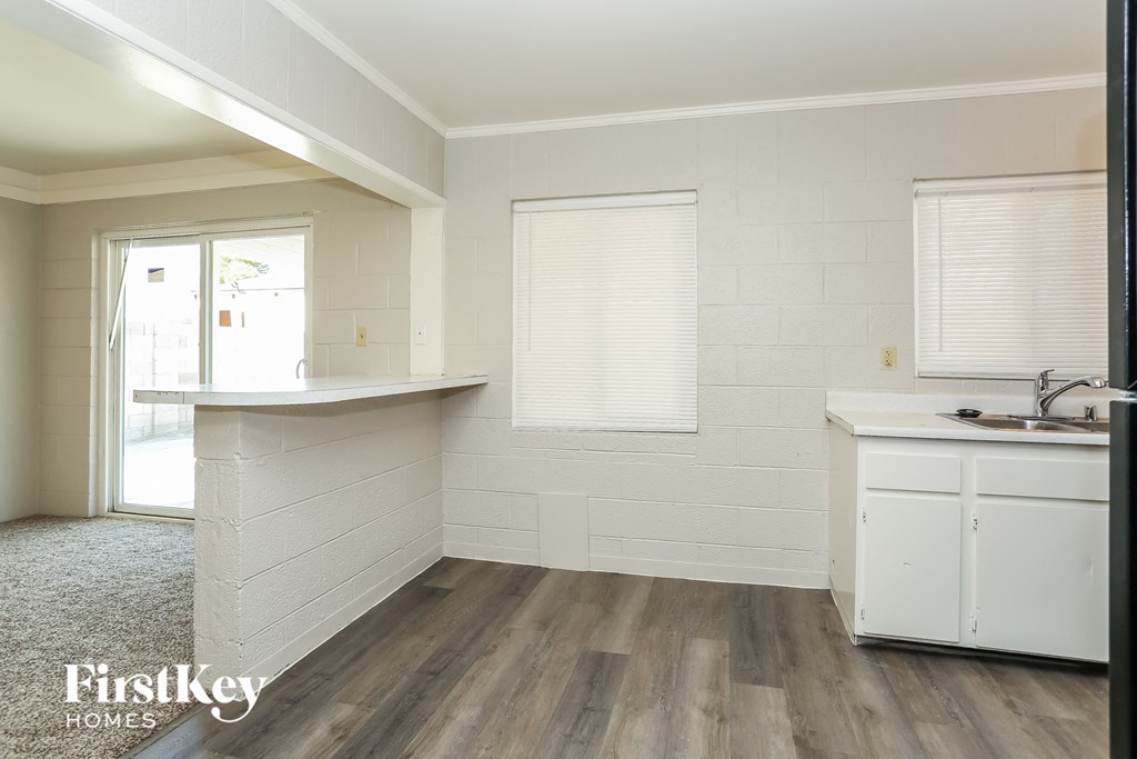A kitchen area with a white counter and cabinets.