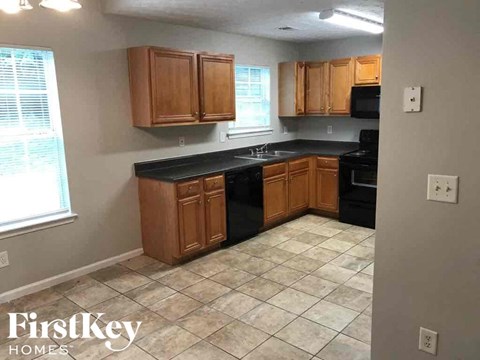 A kitchen with wooden cabinets and black countertops.