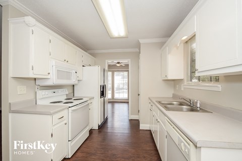 A kitchen with white cabinets and appliances.
