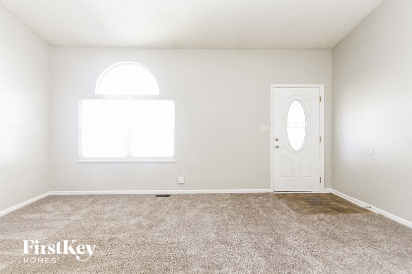 a room with carpet and a door and a window