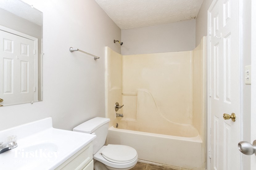 a bathroom with a toilet and a tub and a sink