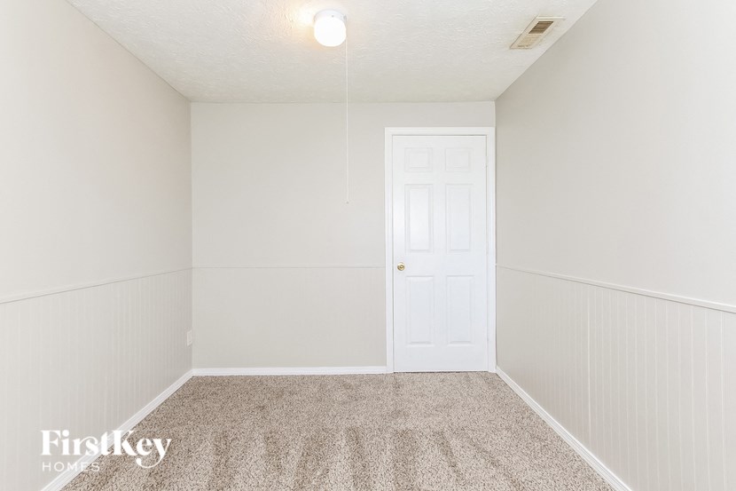 a bedroom with white walls and a white door