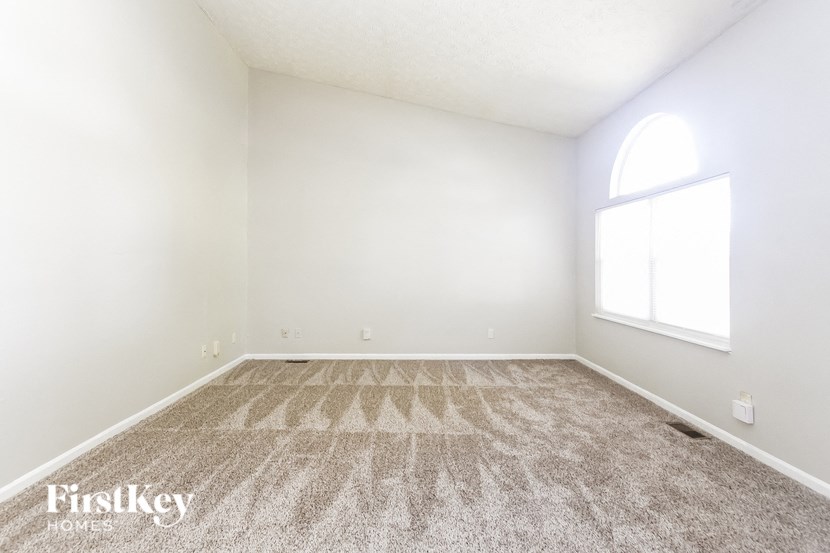 an empty room with carpet and a window