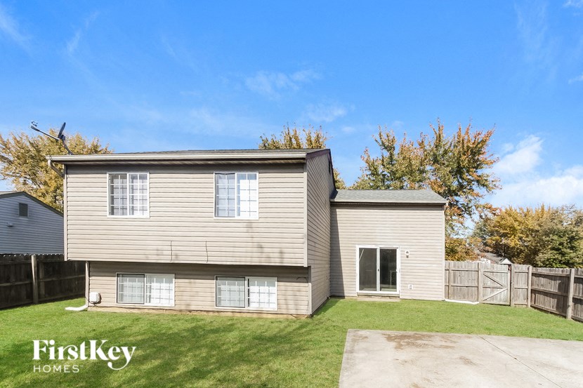 a white house with a yard and a wooden fence