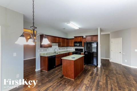 a kitchen with wooden cabinets and a black refrigerator