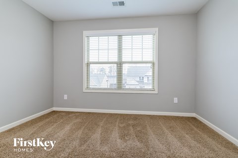 the second bedroom has carpet and a window