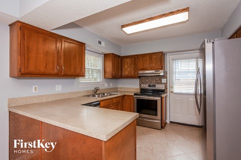 A kitchen with wooden cabinets and a white refrigerator.