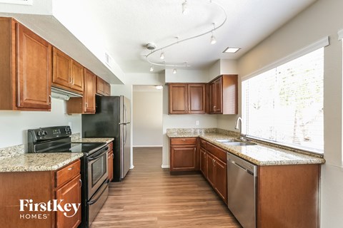 A kitchen with wooden cabinets and a stainless steel refrigerator.