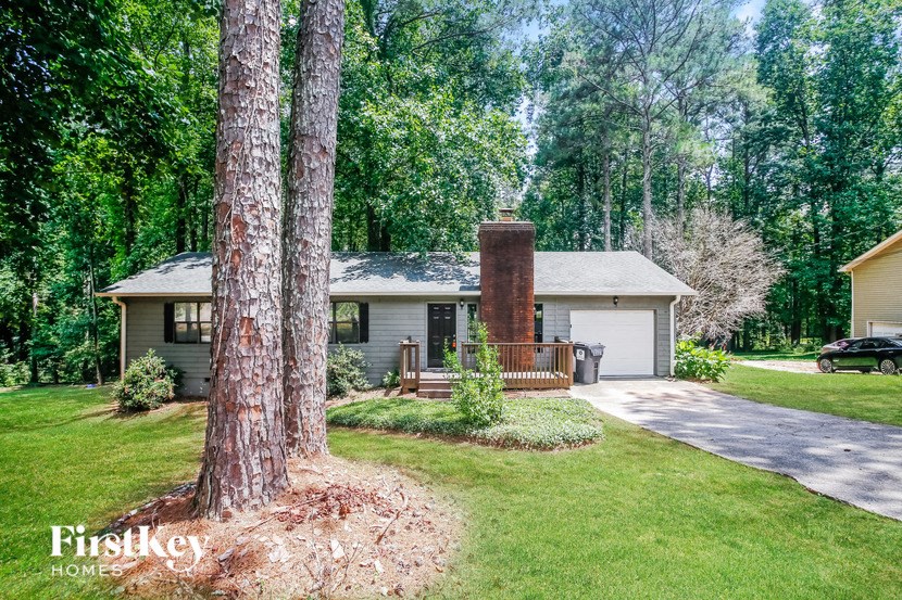 a small white house with a brick chimney in the front