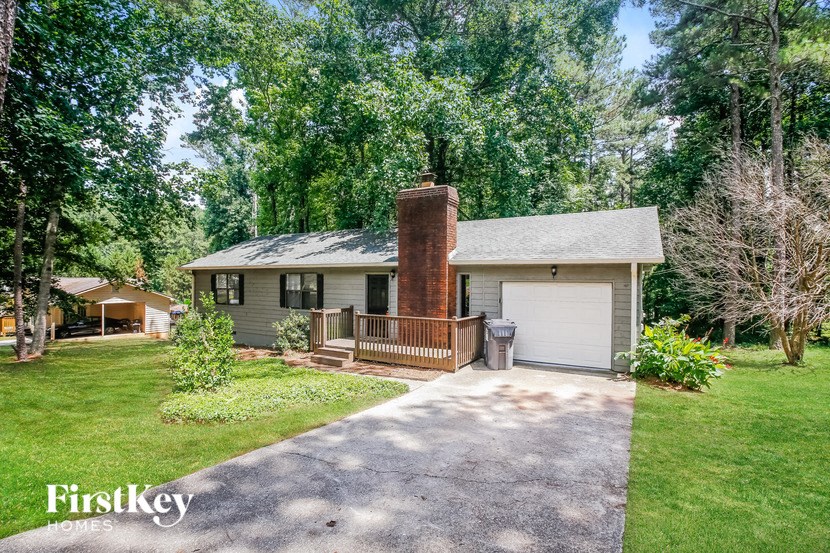 a white house with a brick chimney and a driveway