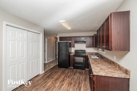 a kitchen with wooden cabinets and a black refrigerator