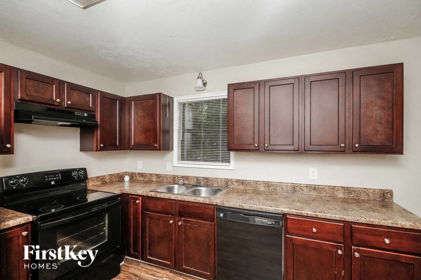 a kitchen with dark wood cabinets and a sink and a stove