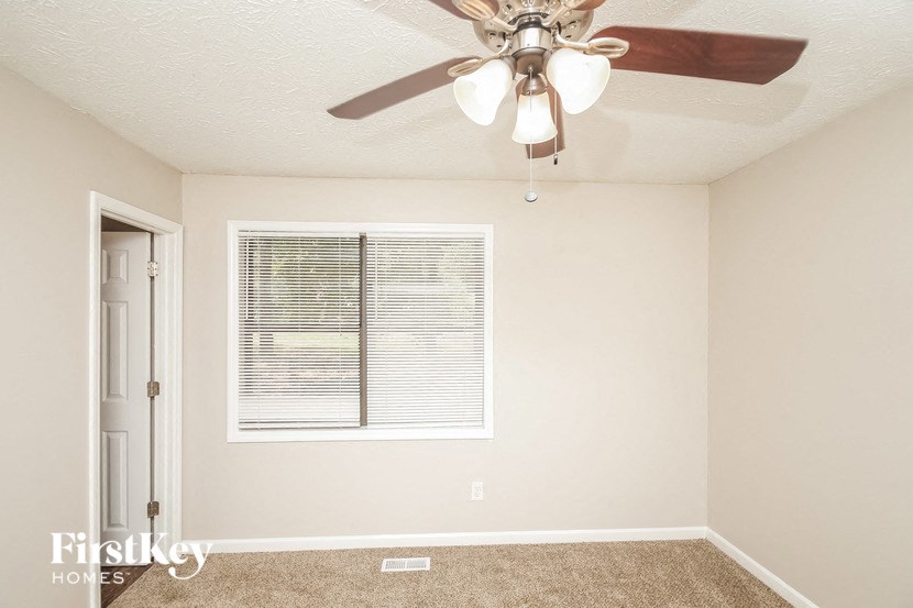 a bedroom with a ceiling fan and a window