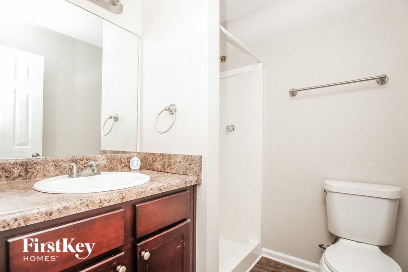 a bathroom with a sink toilet and a mirror