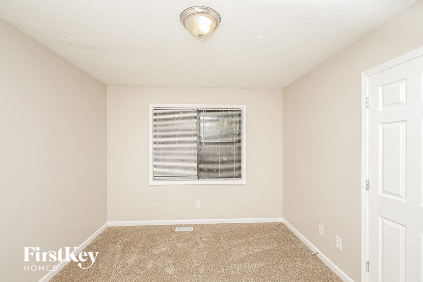 an empty room with a window and a white door