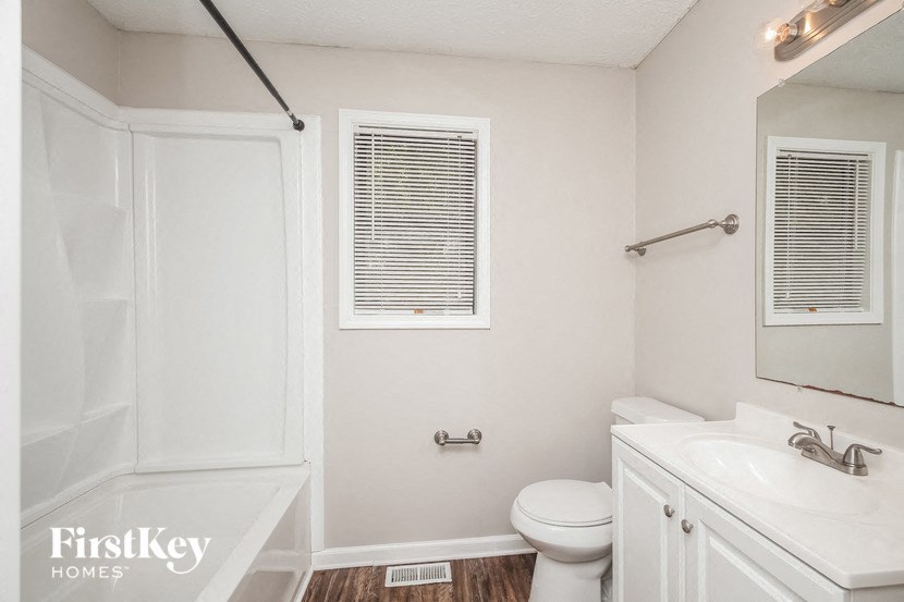 a white bathroom with a sink toilet and a shower