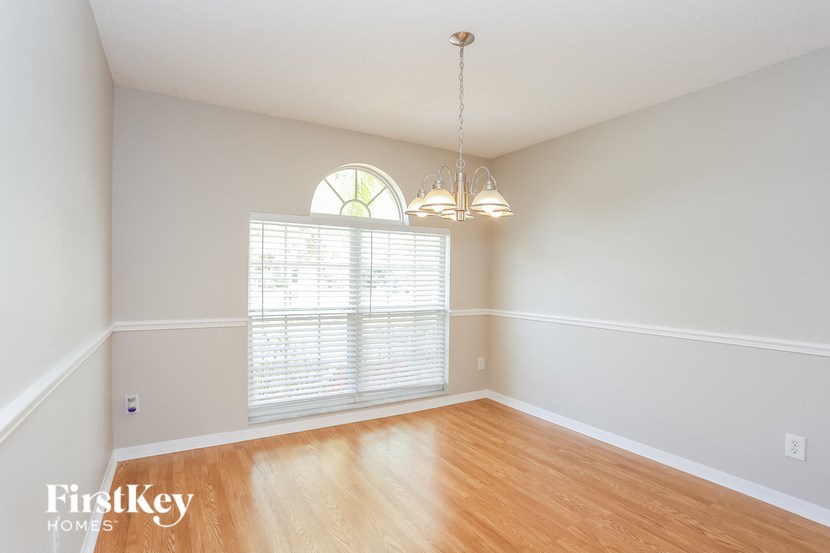 an empty living room with a large window and wood floors