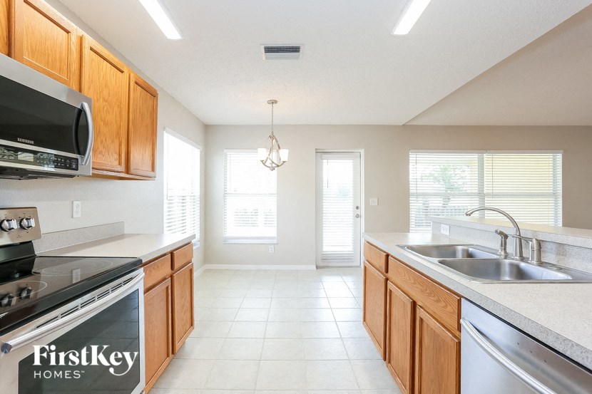 a kitchen with wooden cabinets and a sink and a stove