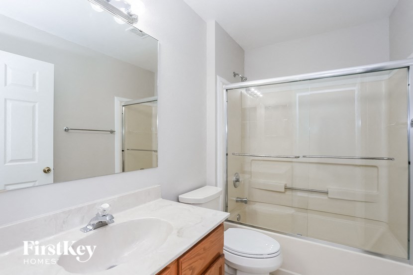 a bathroom with a sink toilet and shower and a mirror