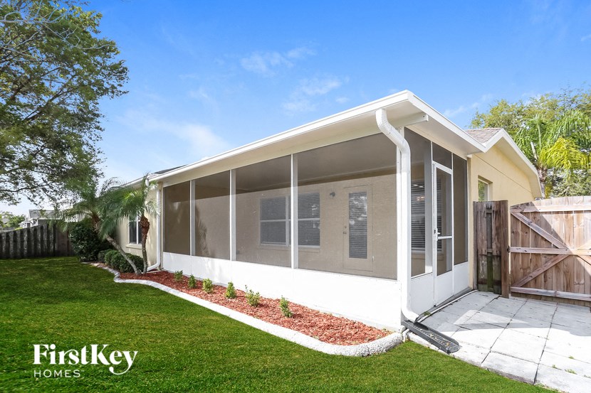 a small yellow house with a lawn and a driveway
