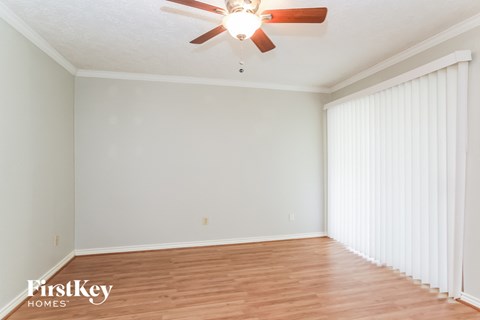 a living room with white walls and a ceiling fan
